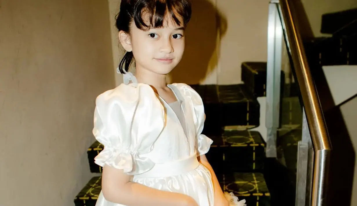Tak hanya jadi aktris, Graciella Abigail juga memulai karier sebagai model cilik. Terbiasa berpose sejak kecil membuat gaya penampilan Graciella Abigail saat di depan kamera sangat memesona. Ia semakin terlihat gemas dengan pose melihat ke kamera. Selain itu, outfit yang dikenakan Graciella warna putih juga pas dikenakannya. (Liputan6.com/IG/@graciellaabigail)
