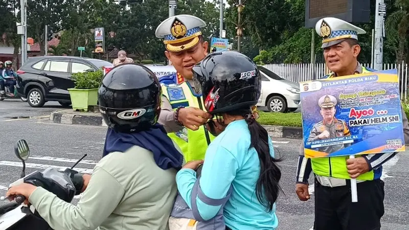 Direktur Lalu Lintas Polda Riau Kombes Taufik Lukman membagikan helm kepada masyarakat agar sadar pentingnya melindungi kepala saat berkendara di jalan raya.