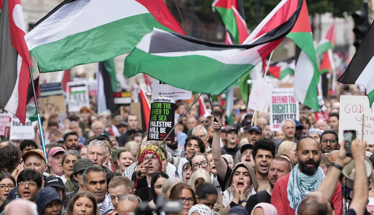 Para pendukung pro-Palestina memegang plakat dan mengibarkan bendera di Downing Street di pusat kota London, Inggris pada 19 Juli 2025. (CARLOS JASSO/AFP)