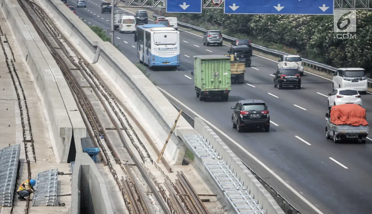 Pekerja menyelesaikan pembangunan proyek kereta api ringan atau LRT di kawasan Kampung Makasar, Jakarta, Kamis (26/7). Proyek LRT Jakarta diusahakan selesai sesuai target, yakni seminggu sebelum Asian Games 2018. (Liputan6.com/Faizal Fanani)