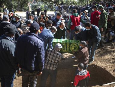 Peti jenazah Rayan Oram (5) diturunkan ke dalam makam saat pemakamannya di Desa Ighran, Provinsi Chefchaouen, Maroko, 7 Februari 2022. Rayan Oram meninggal setelah terjebak selama lima hari dalam sumur kering sedalam 32 meter. (AP Photo/Mosa'ab Elshamy)