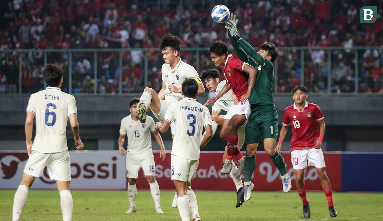 <p>Pemain Timnas Indonesia U-19,&nbsp;Ahmad Rusadi berebut bola diudara dengan penjaga gawang Thailand yang dijaga Narongsak Naengwongsa dalam pertandingan babak penyisihan Grup A Piala AFF U-19 yang berlangsung di Stadion Patriot Candrabhaga, Bekasi, Rabu (6/7/2022). (Bola.com/Bagaskara Lazuardi)</p>
