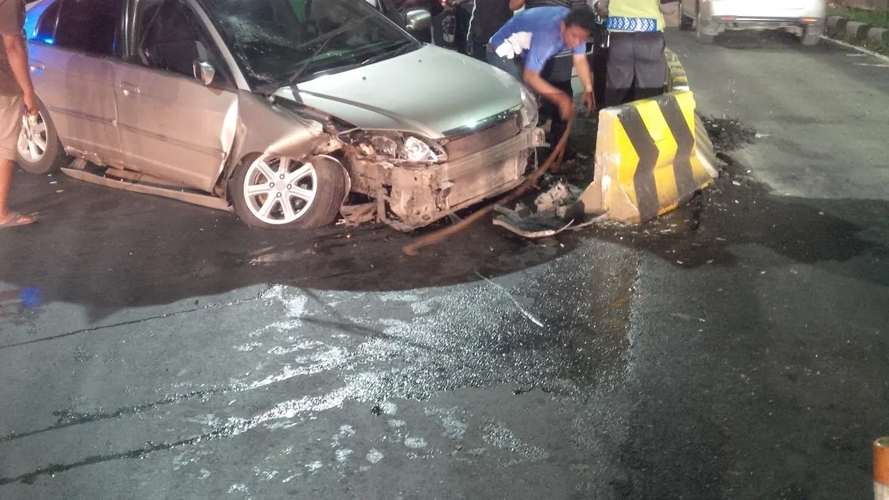 Polisi evakuasi mobil penabrak separator Busway di Pancoran, Jakarta Selatan (Oscar Ferri/ Liputan6.com)