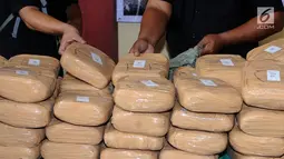  Petugas memperlihatkan barang bukti 225 kg ganja saat rilis di RS Polri Kramat Jati Jakarta, Rabu (30/8). Satresnarkoba Polda Metro Jaya menggagalkan peredaran 225 kg ganja asal Aceh serta menangkap satu tersangka. (Liputan6.com/Helmi Fithriansyah)