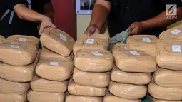 Petugas memperlihatkan barang bukti 225 kg ganja saat rilis di RS Polri Kramat Jati Jakarta, Rabu (30/8). Satresnarkoba Polda Metro Jaya menggagalkan peredaran 225 kg ganja asal Aceh serta menangkap satu tersangka. (Liputan6.com/Helmi Fithriansyah)