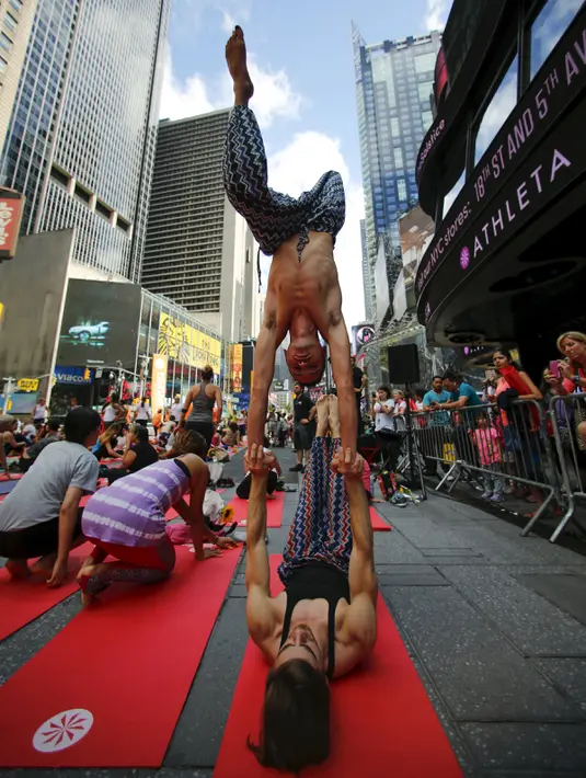 Warga berpose ketika melakukan gerakan yoga di tengah jalan saat perayaan Summer Solstice di Hari Yoga Internasional di Times Square, New York, Minggu (21/6/2015). (REUTERS/Eduardo Munoz)