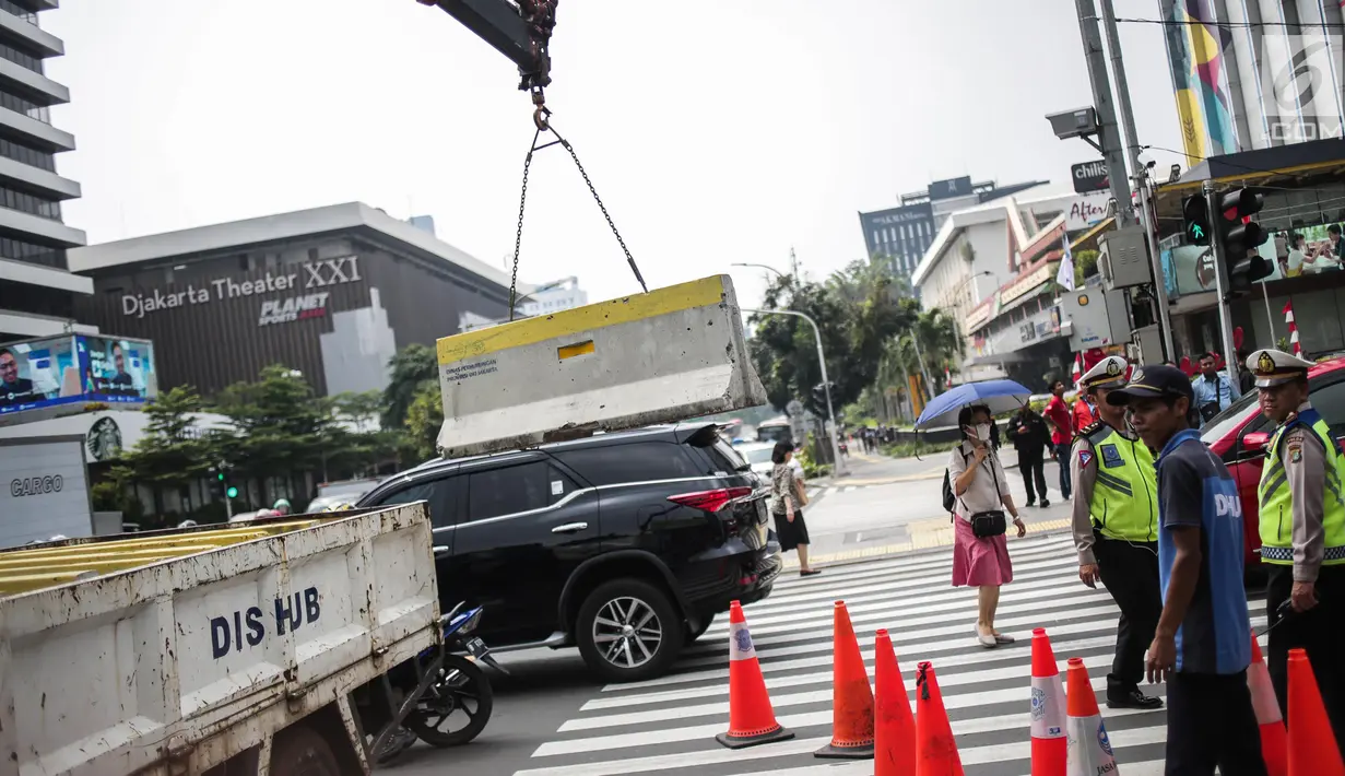 Petugas Dishub memindahkan separator beton untuk menutup sebagian jalan di depan kantor Bawaslu RI, Jakarta, Selasa (21/5/2019). Aparat kepolisian memperketat penjagaan gedung Bawaslu untuk aksi 22 Mei atau setelah penetapan hasil rekapitulasi suara Pemilu 2019 oleh KPU. (Liputan6.com/Faizal Fanani)