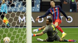 Pada menit ke-40 Barcelona akhinya unggul 1-0 lewat gol Robert Lewandowski. Gol dicetak lewat tembakan rebound yang sempat diblok bek Real Betis, namun akhirnya jatuh kembali ke kaki Lewandowski yang dengan mudah menaklukkan kiper Betis, Claudio Bravo. Keunggulan satu gol Barcelona bertahan hingga babak pertama usai. (AFP/Giuseppe Cacace)