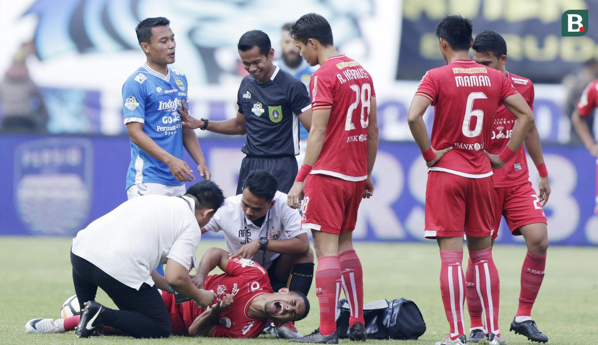 Gelandang Persija Jakarta, Renan da Silva, meringis kesakitan usai dilanggar pemain Persib Bandung pada laga Liga 1 di Stadion GBLA, Jawa Barat, Minggu (23/9/2018). Persib menang 3-2 atas Persija. (Bola.com/M Iqbal Ichsan)