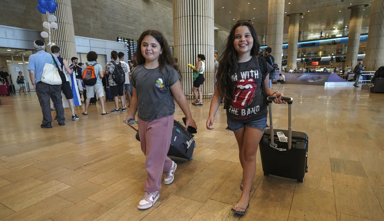 Dua gadis yang tiba dari negara kepulauan Seychelles di Samudra Hindia yang melakukan pemberhentian darurat di Arab Saudi bereaksi saat mendarat di Bandara Ben Gurion di Lod, dekat Tel Aviv, Israel, Selasa (29/8/2023). (AP Photo/Tsafrir Abayov)