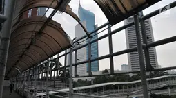 Pemandangan jembatan penyeberangan orang (JPO) yang berada di Jalan Sudirman, Jakarta, Rabu (17/4). Atap JPO yang yang rusak mengganggu pejalan kaki ketika hujan turun. (Merdeka.com/Iqbal Nugroho)
