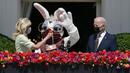 Presiden Joe Biden menyaksikan Ibu Negara Jill Biden menyerahkan bunga kepada Kelinci Paskah selama acara Paskah di Gedung Putih, Washington, Amerika Serikat, Senin (5/4/2021). Gedung Putih kembali meniadakan tradisi Easter Egg Roll menyusul pandemi COVID-19. (AP Photo/Evan Vucci)