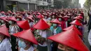 Guru sekolah antikudeta mengenakan seragam dan topi tradisional Myanmar menunjukkan penghormatan tiga jari saat berdemonstrasi di Mandalay, Myanmar, Rabu (3/3/2021). Demonstran di Myanmar turun ke jalan lagi pada hari Rabu untuk memprotes perebutan kekuasaan bulan lalu oleh militer. (AP Photo)