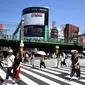 Sejumlah orang menggunakan payung dan topi untuk melindungi dirinya dari sinar matahari selama gelombang panas saat melintasi jalan di distrik Shinjuku Tokyo, Minggu (4/8/2019). Setelah menyerang beberapa wilayah di Eropa, suhu tinggi juga terjadi di Jepang. (Charly TRIBALLEAU / AFP)