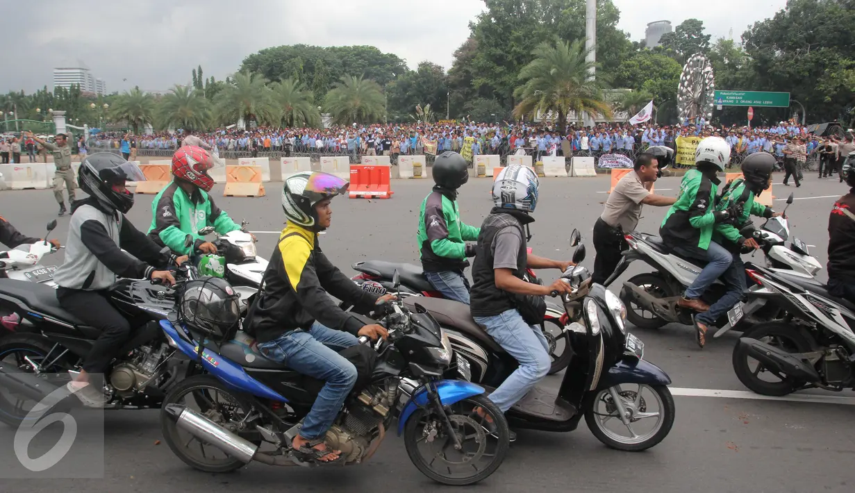 Pengemudi ojek online dilempari batu oleh sopir taksi yang melakukan unjuk rasa di depan Istana Negara, Jakarta, Selasa (22/3). Aksi itu pecah saat pengunjuk rasa mendapat ejekan dari pengemudi ojek online. (Liputan6.com/Gempur M Surya)