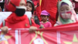 Seorang anak terlihat dalam aksi unjuk rasa menolak pengesahan UU Omnibus Law Cipta Kerja di Kawasan Patung Kuda, Jakarta, Jumat (16/10/2020). Meski sudah ada imbauan untuk tidak membawa anak-anak dalam aksi unjuk rasa namun sejumlah orang tua tetap menyertakan. (Liputan6.com/Helmi Fithriansyah)