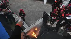 Seorang pria membakar diri dan terjun dari atap stadion Gelora Bung Karno, Jakarta, Jumat (1/5/2015). Sejumlah buruh tampak berusaha memadamkan api dengan air minum. (Liputan6.com/Herman Zakharia)