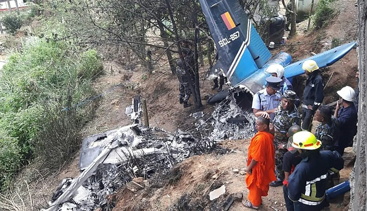 Petugas penyelamat memeriksa puing-puing pesawat milik AU Sri Lanka yang jatuh di daerah pegunungan penghasil teh di Haputale, Jumat (3/1/2020). Pesawat Y-12 buatan China lepas landas dari pangkalan udara Wirawila menuju Ratmalana, selatan Kolombo. (Photo by STR / AFP)