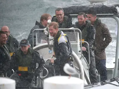Pangeran Harry menaiki sebuah kapal boat di bawah rintikan hujan, usai menghadiri jumpa pers di Sydney Harbour di Australia, (7/6). Invictus Games merupakan pekan olahraga internasional yang dibuat oleh Pangeran Harry. (AP Photo/Rick Rycroft)