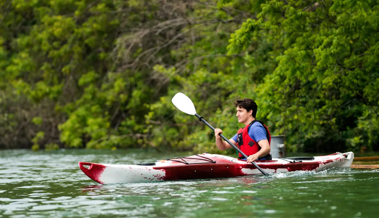 Perdana Menteri (PM) Kanada Justin Trudeau mengayuh perahu kayak dengan dayung mengarungi aliran Sungai Niagara, Ontario, Senin (5/6). Aksi PM Kanada ini untuk memperingati Hari Lingkungan Hidup Sedunia. (Nathan Denette/The Canadian Press via AP)