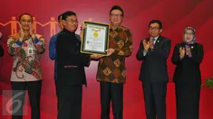Mendagri Tjahjo Kumolo menerima piagam rekor MURI usai melakukan penandatangan kerja sama pemanfaatan data kependudukan dengan 100 pelaku usaha Bursa Efek Indonesia (BEI) di Gedung BEI, Jakarta, Selasa (22/11). (Liputan6.com/Angga Yuniar)