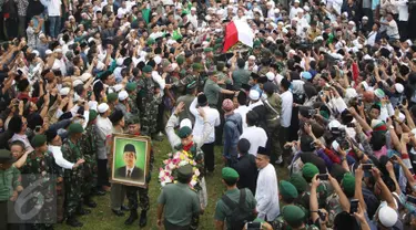 Pelayat mengangkat keranda jenazah tokoh PBNU KH Hasyim Muzadi jelang pemakaman di Ponpes Al-Hikam, Kukusan, Beji, Depok, Kamis (16/3). Jenazah KH Hasyim Muzadi dimakamkan secara militer dengan iringan lantunan tahlil. (Liputan6.com/Immanuel Antonius)