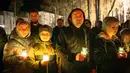 Orang-orang membawa lilin di tugu peringatan yang didedikasikan untuk petugas pemadam kebakaran dan pekerja yang meninggal setelah bencana nuklir Chernobyl, menjelang peringatan 40 tahunnya di Slavutych, Ukraina, Sabtu, 25 April 2026. (AP Photo/Dan Bashakov)