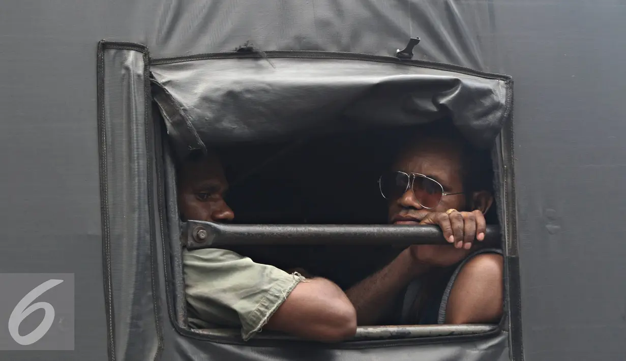 Mahasiswa Papua berada di dalam mobil petugas usai berunjuk rasa di kawasan Bunderan HI, Jakarta, Selasa (1/12). Massa menyerahkan diri sebagai bentuk solidaritas usai puluhan lainnya diamankan petugas pascabentrok. (Liputan6.com/Immanuel Antonius)