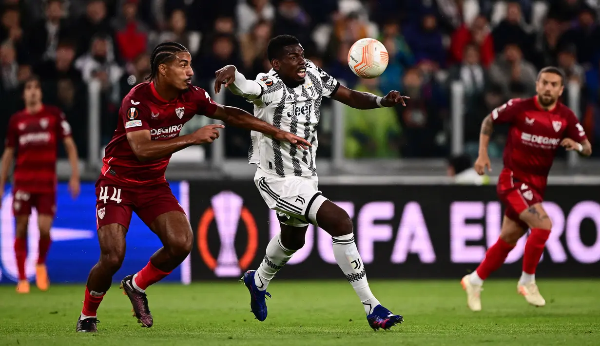 Pemain Juventus, Paul Pogba berusaha melewati penjagaan dari pemain Sevilla, Loic Bade pada laga leg pertama semifinal Liga Europa 2022/2023 di Allianz Stadium, Juventus, Jumat (12/05/2023) WIB. Laga berakhir dengan skor 1-1. (AFP/Marco Bertorello)
