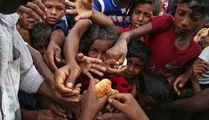 Anak-anak etnis Rohingya dari Myanmar merentangkan tangan mereka untuk menerima makanan yang didistribusikan oleh penduduk setempat di Kamp Pengungsian Kutupalong di Cox's Bazar, Bangladesh, 30 Agustus 2017. (AP Photo/Mushfiqul Alam)