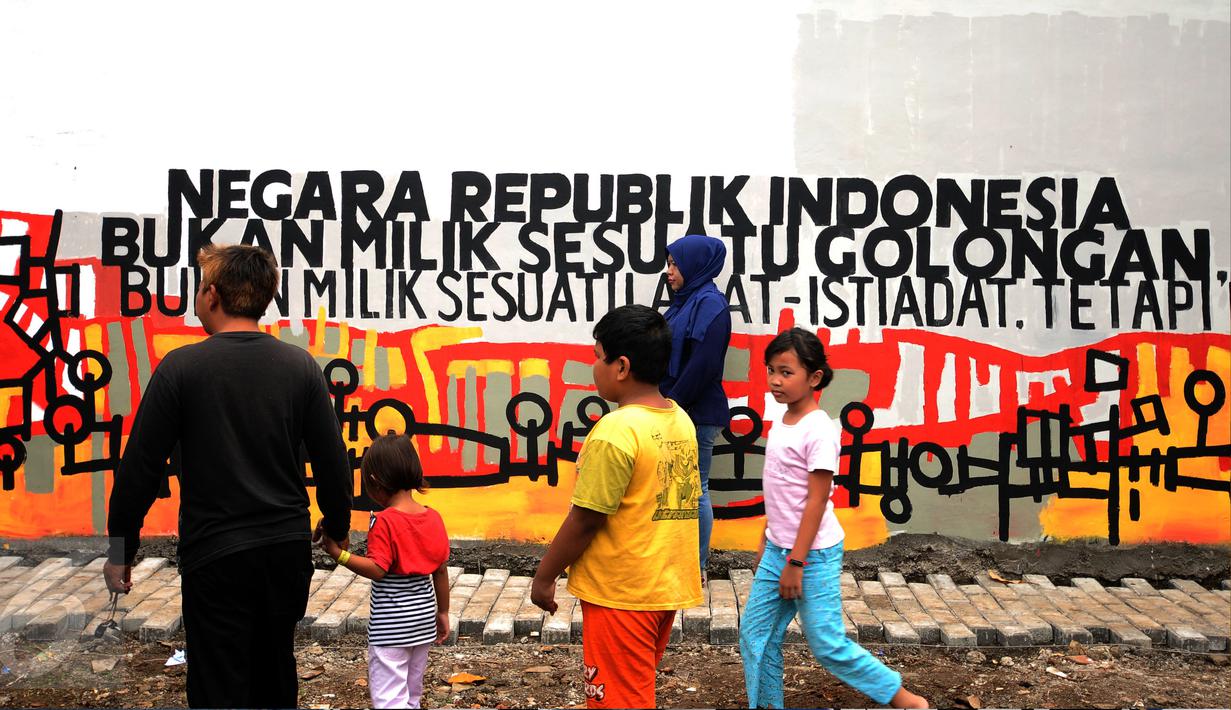 Warga melintas di depan tulisan toleransi di Lapangan Kebagusan, Jakarta, Rabu (15/2). Jelang menggunakan hak pilihnya pada Pilkada, Ketua Umum PDI-P Megawati Soekarnoputri menggoreskan tinta pada salah satu gambar. (Liputan6.com/Helmi Fithriansyah)