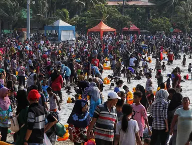 Warga memanfaatkan libur Idul Fitri 1440 H dengan memadati kawasan Beach Pool, Taman Impian Jaya Ancol, Jakarta, Kamis (6/6/2019). Sejumlah kawasan wisata di ibukota termasuk Taman Impian Jaya Ancol menjadi tujuan wisata masyarakat menghabiskan libur lebaran 2019. (Liputan6.com/Johan Tallo)