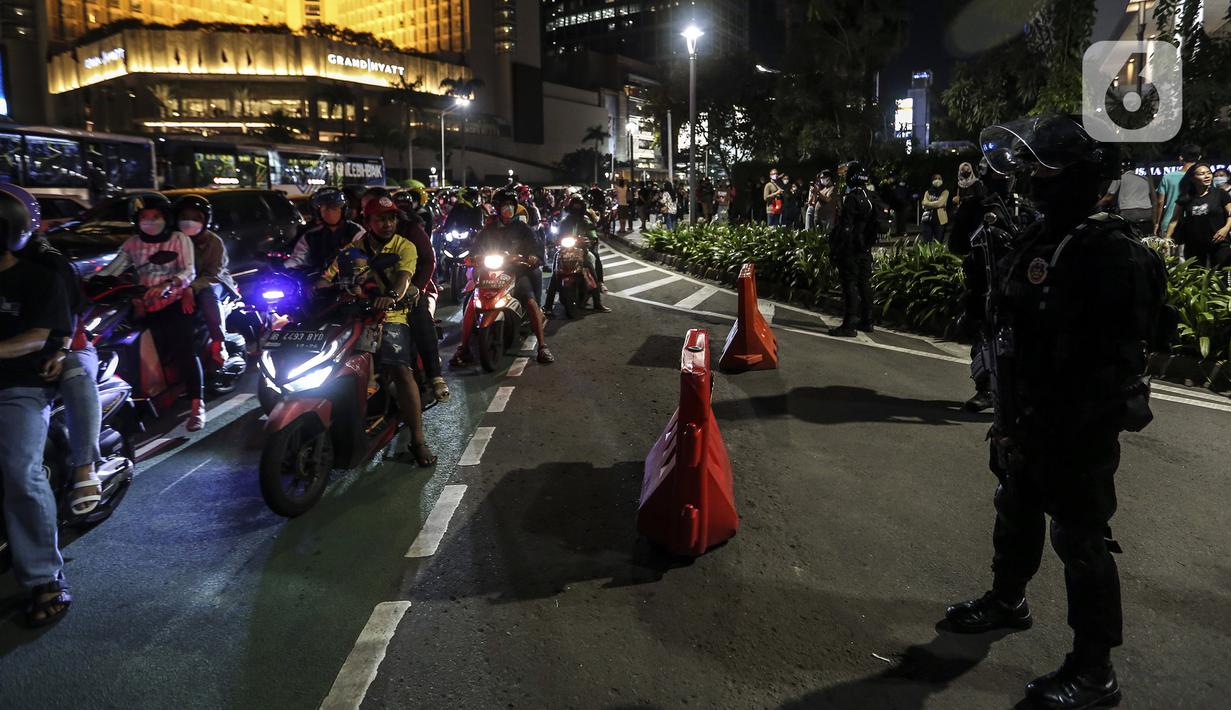Suasana mobilitas warga saat perayaan malam Tahun Baru di Jakarta, Jumat (31/12/2021). Polda Metro Jaya melakukan pengendalian mobilitas Crowd Free Night (malam bebas keramaian) dengan membubarkan warga yang nekat keluar rumah dan tidak mematuhi aturan. (Liputan6.com/Johan Tallo)