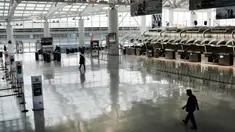 Orang-orang berjalan melalui terminal keberangkatan internasional yang sepi di Bandara John F. Kennedy (JFK), New York City, Sabtu (8/3/2020). Maskapai penerbangan terpukul wabah virus corona (COVID-19) setelah pelancong bisnis maupun rekreasi membatalkan rencana. (Spencer Platt/Getty Images/AFP)