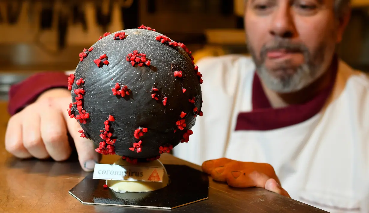 Pembuat cokelat, Jean-François Pre menyiapkan telur paskah berbentuk seperti Virus Corona di tokonya di Landivisiau, Prancis, 7 Maret 2020. Cokelat ini terbuat dari cokelat putih yang diberikan pewarna hitam serta dipadukan dengan kacang almond yang diwarnai merah. (Damien MEYER/AFP)