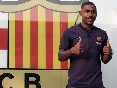 Pemain baru Barcelona, Malcom Filipe Silva de Oliveira, berpose dihadapan media saat tiba di Stadion Camp Nou, Barcelona, Selasa (24/7/2018). Blaugrana resmi mendapatkan jasa pemain Bordeaux ini dengan harga 41 juta euro. (AP/Manu Fernandez)