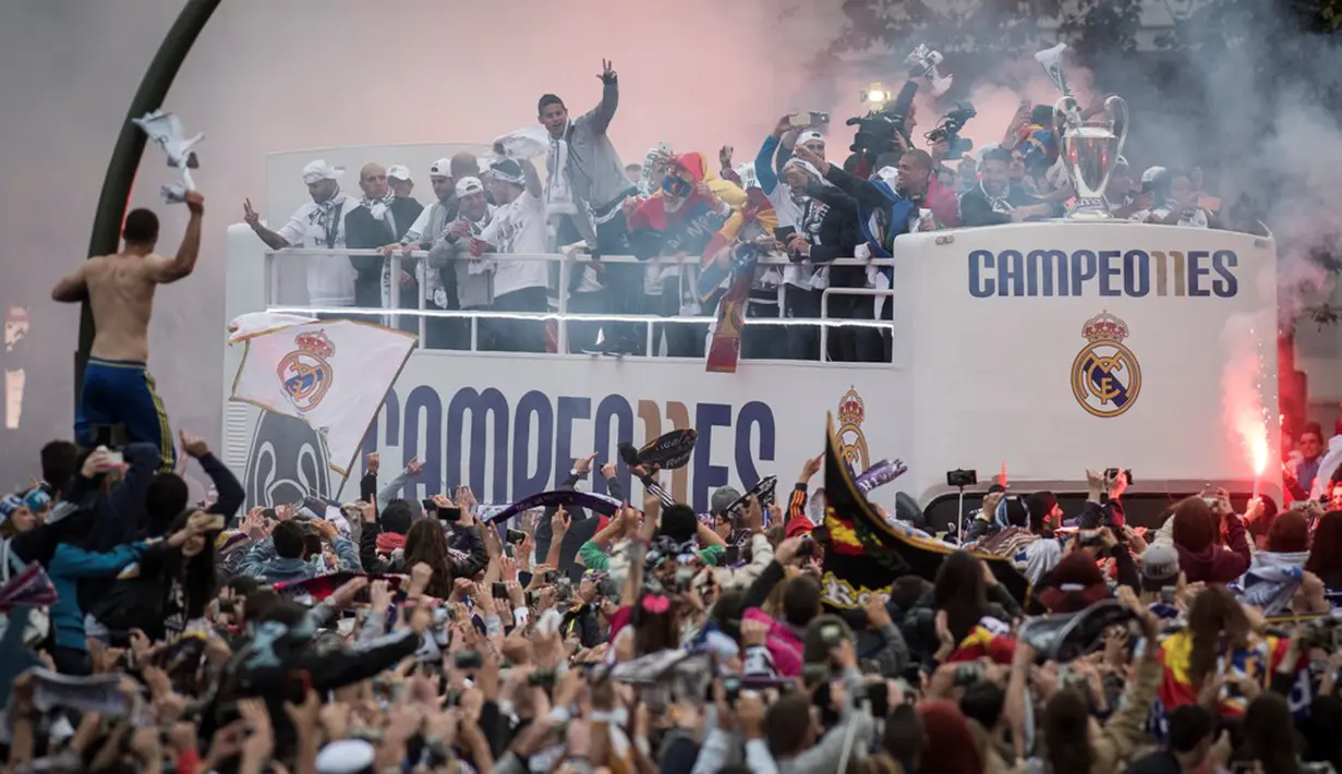 Suporter Real Madrid menyambut timnya saat tiba di Plaza Cibeles, Madrid, Senin (29/5/2016) dalam parade juara Liga Champions. (AFP/Pedro Armestre)