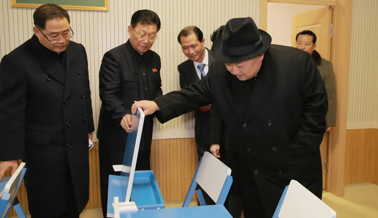 Pemimpin Korea Utara Kim Jong-Un memeriksa kursi untuk mahasiswa saat mengunjungi Universitas Guru Pyongyang yang baru direnovasi di Pyongyang (17/1). (KCNA VIA KNS/AFP)