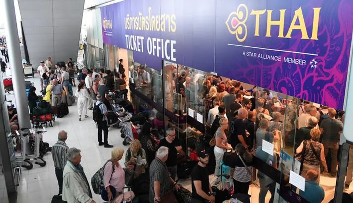 Penumpang menunggu di loket tiket Thai Airways di Bandara Internasional Suvarnabhumi di Bangkok (28/2). Pembatalan penerbangan tersebut karena konflik yang memanas antara India dan Pakistan di perbatasan Kashmir. (AFP Photo/Lillian Suwnrumpha)