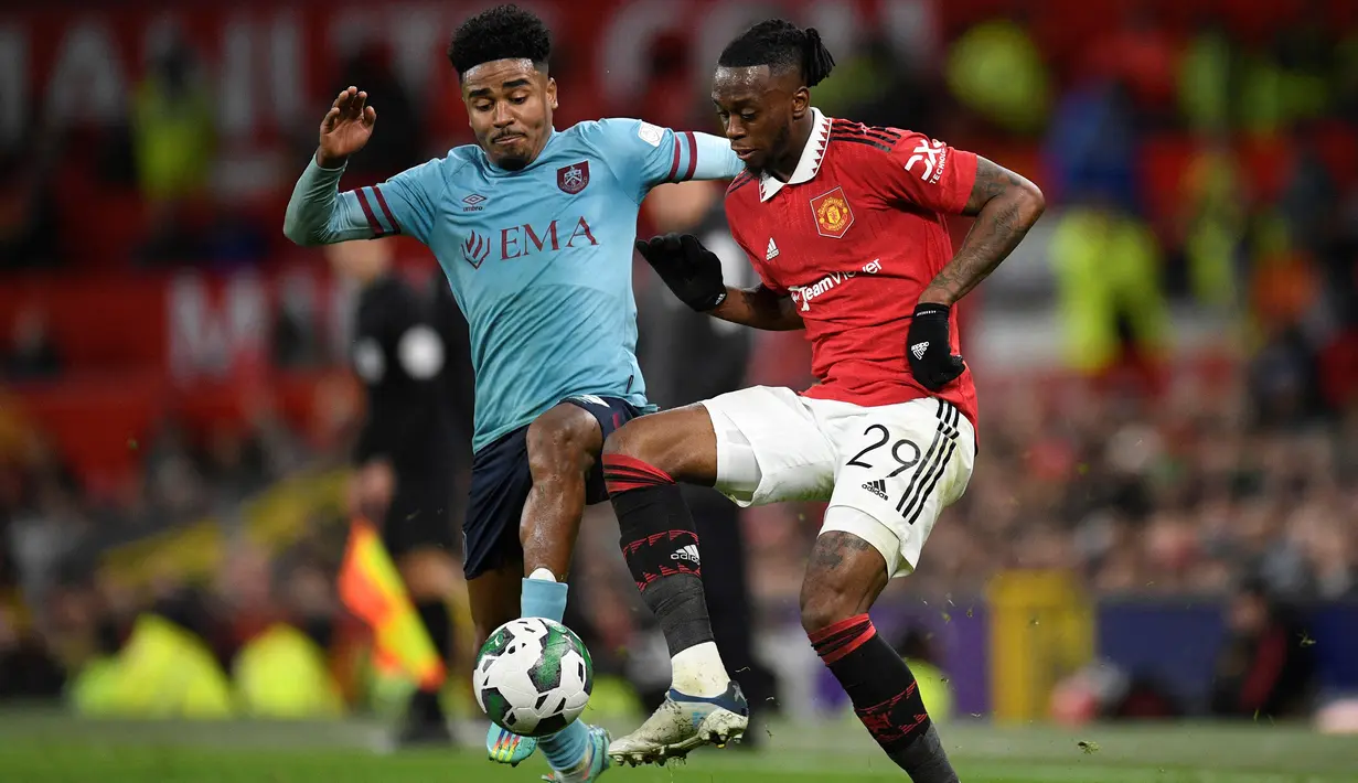 Bek Burnley, Ian Maatsen (kanan) berebut bola dengan bek Manchester United, Aaron Wan-Bissaka pada laga putaran keempat Piala Liga Inggris 2022/2023 di Old Trafford Stadium, Manchester (21/12/2022). Ian Maatsen dipinjam Burnley dari Chelsea U-21 pada awal musim 2022/2023. Pemain asal Belanda ini telah tampil dalam 34 laga di Championship dengan torehan 4 gol dan 6 assist. (AFP/Oli Scarff)