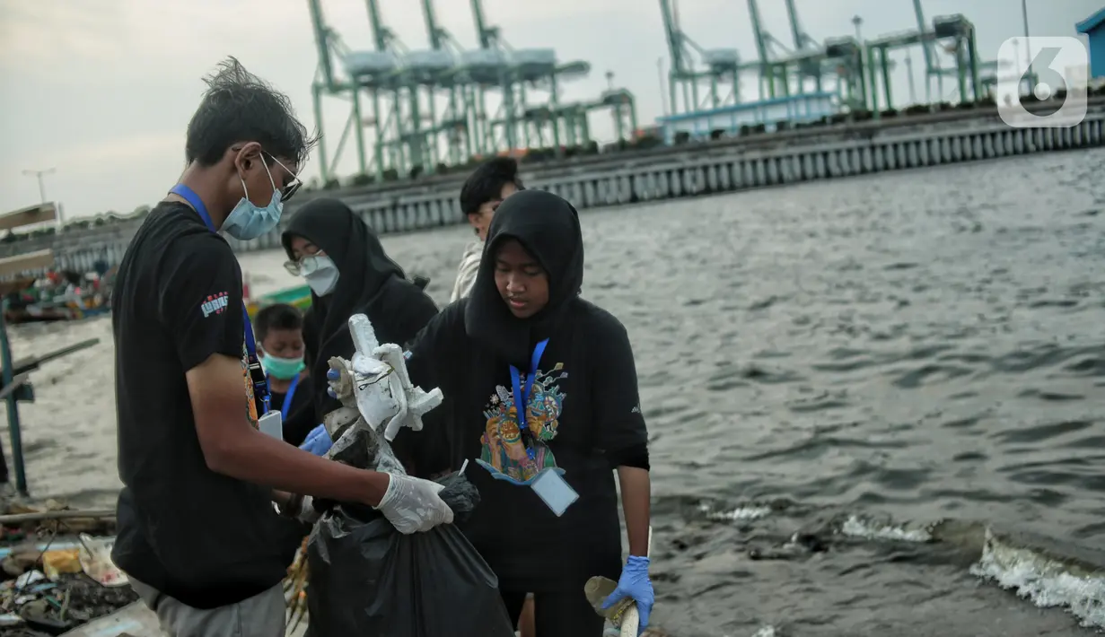 Anak-anak pesisir dan sukarelawan saat membersihkan sampah di Pemukiman Nelayan Manunggal, Cilincing, Jakarta Utara, Minggu (18/9/2022). Tumpukan sampah yang berserakan di kawasan pemukiman nelayan Manunggal, Cilincing menginisasi Kelas Jurnalis Cilik untuk membersihkan sampah dan mengedukasi kepada anak-anak pesisir serta masyarakat pentingnya menjaga kebersihan di lingkungan sekitar. (merdeka.com/Iqbal S. Nugroho)