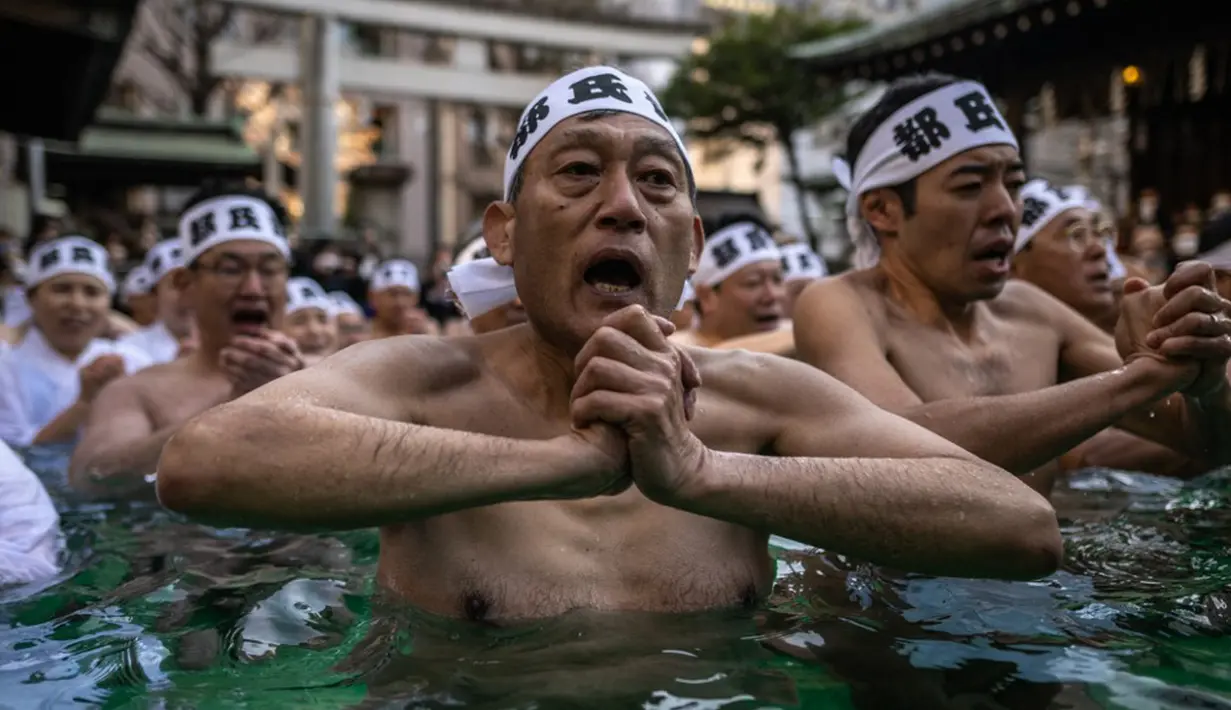 Penganut Shinto mandi dengan air dingin di Kuil Teppozu Inari, Tokyo, Jepang, 8 Januari 2023. Ritual Tahun Baru ini dilakukan untuk memurnikan jiwa dan raga. (Philip FONG/AFP)
