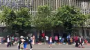 Pedagang kaki lima (PKL) menggantungkan pakaian-pakaian dagangannya di pagar kantor saat pelaksanaan car free day (CFD) di Jakarta, Minggu (11/2). (Liputan6.com/Immanuel Antonius)