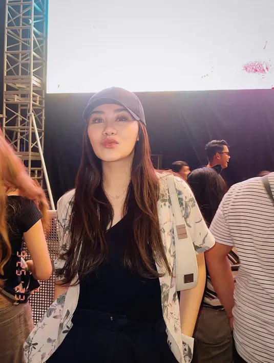 Untuk tampilan nonton konser, Aaliyah memadukan kaus hitam dengan kemeja bermotif. Kemeja berbahan ringan itu nampak membuat Aaliyah nyaman, ditambah dengan aksesori topi juga handbad. [Foto: Instagram/aaliyah.massaid]