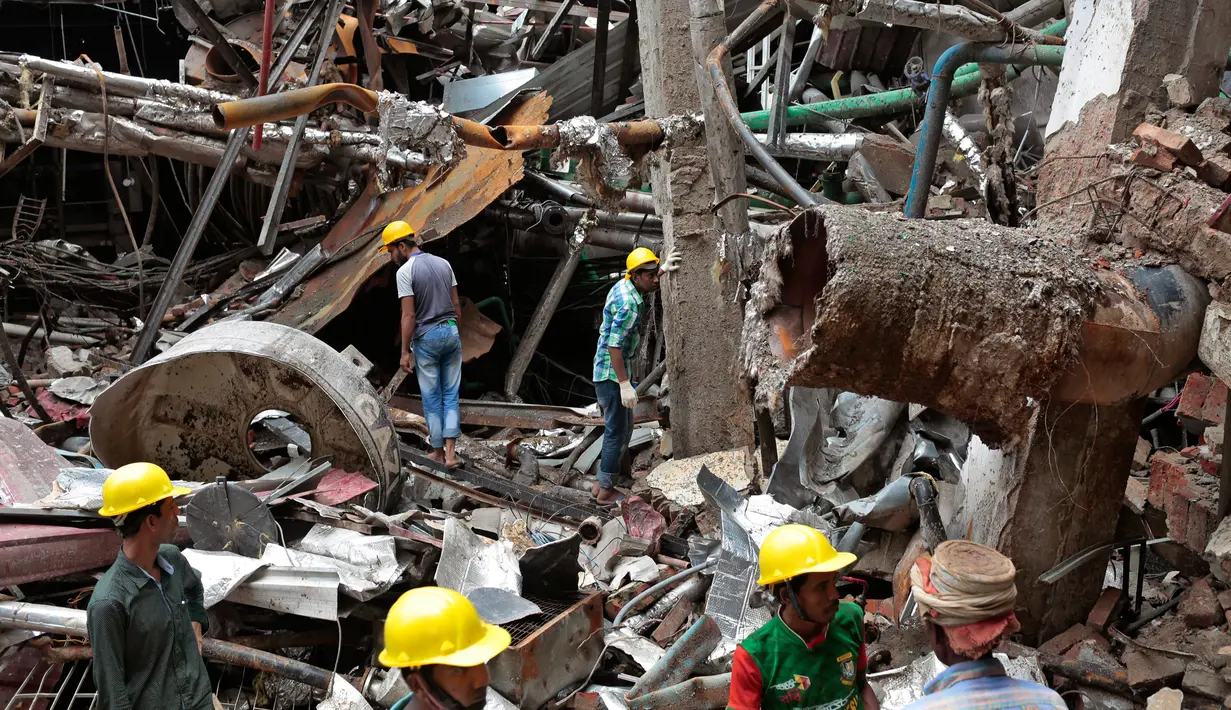 Tim penyelamat Bangladesh berdiri di puing-puing bekas ledakan pabrik di Dhaka, Bangladesh (4/7). Akibat ledakan tersebut 10 orang tewas dan puluhan lainnya mengalami luka cukup serius. (AP Photo / AM Ahad)