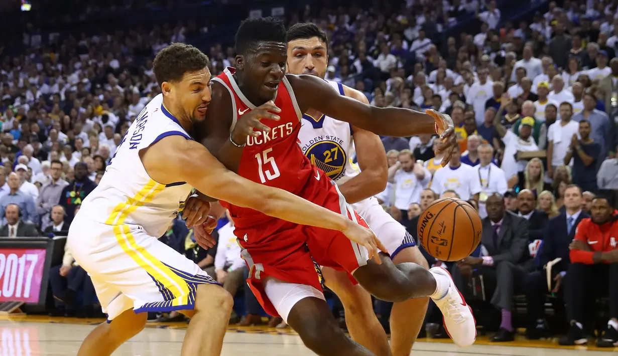 Pebasket Warriors, Klay Thompson #11 berebut bola dengan pebasket Houston, Clint Capela #15 pada laga perdana NBA 2017 di Oracle Arena, Oakland, (17/10/2017).  Rockets menang 122-121. Rockets menang 122-121. (Ezra Shaw/Getty Images/AFP)