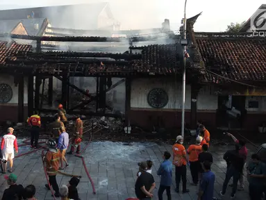Petugas pemadam kebakaran dan warga berkumpul di lokasi kebakaran yang melanda kompleks Kelenteng Tay Kak Sie di Gang Lombok, Semarang, Kamis (21/3). Dilaporkan satu orang tewas dalam insiden kebakaran ini. (Liputan6.com/Gholib)