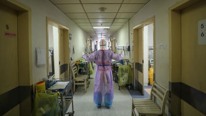 Petugas medis melakukan peregangan di rumah sakit Palang Merah di Wuhan pada 28 Februari 2020. Jumlah korban meninggal akibat virus corona (Covid-19) di seluruh dunia hingga Minggu (8/3) pagi sudah mencapai 3.570 orang, terbanyak masih di China. (STR/AFP)
