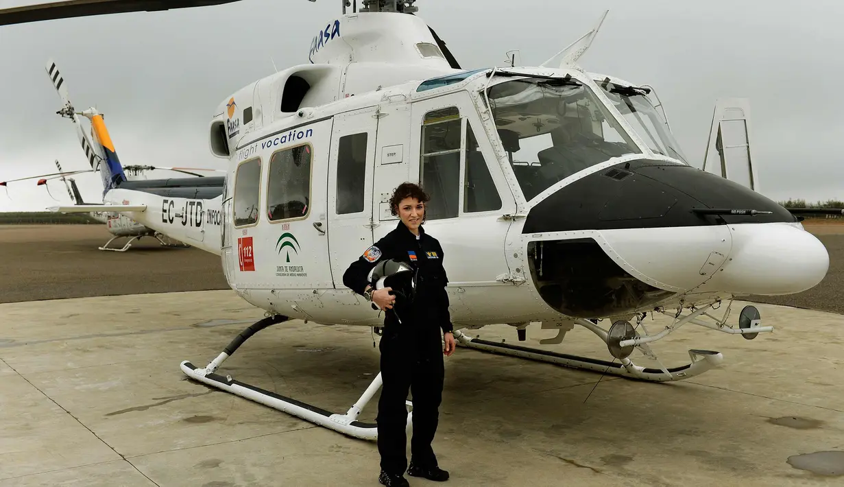 Carla Rozalen berpose di samping helikopter utilitas bermesin ganda Bell 412 di FAASA Group di Palma del Rio, Cordoba (27/2). Carla merupakan satu-satunya pilot wanita Grup Faasa dan bekerja menangani kebakaran hutan.  (AFP Photo/Cristina Quicler)