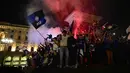 Di bawah guyuran hujan gerimis, pendukung Inter Milan tetap berkumpul hingga dini hari untuk menyalakan suar (flares) dan menyanyikan yel-yel kemenangan di bawah ikon katedral Duomo. Tampak dalam foto, para pendukung Inter Milan merayakan gelar juara Serie A musim 2025/2026 atau scudetto ke-21 di Piazza Duomo, Milan, Italia, Minggu (3/4/2026) malam waktu setempat atau Senin (4/5/2026) dini hari WIB. (PIERO CRUCIATTI/AFP)